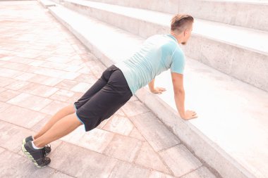 Sportif genç adam dışarıda antrenman yapıyor.