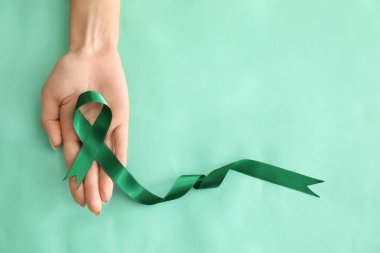 Yeşil şerit renk arka plan üzerinde tutan kadın. Böbrek kanseri bilinçlendirme kavramı