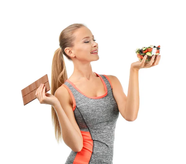 Спортивная Женщина Выбирает Между Свежим Овощным Салатом Шоколадом Белом Фоне — стоковое фото