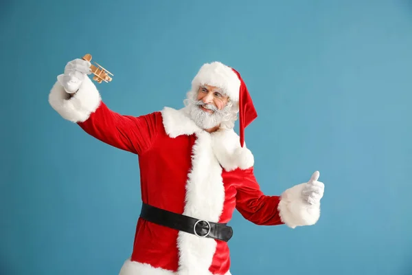 Porträt Des Weihnachtsmannes Der Mit Spielzeugflugzeug Auf Farbigem Hintergrund Spielt — Stockfoto