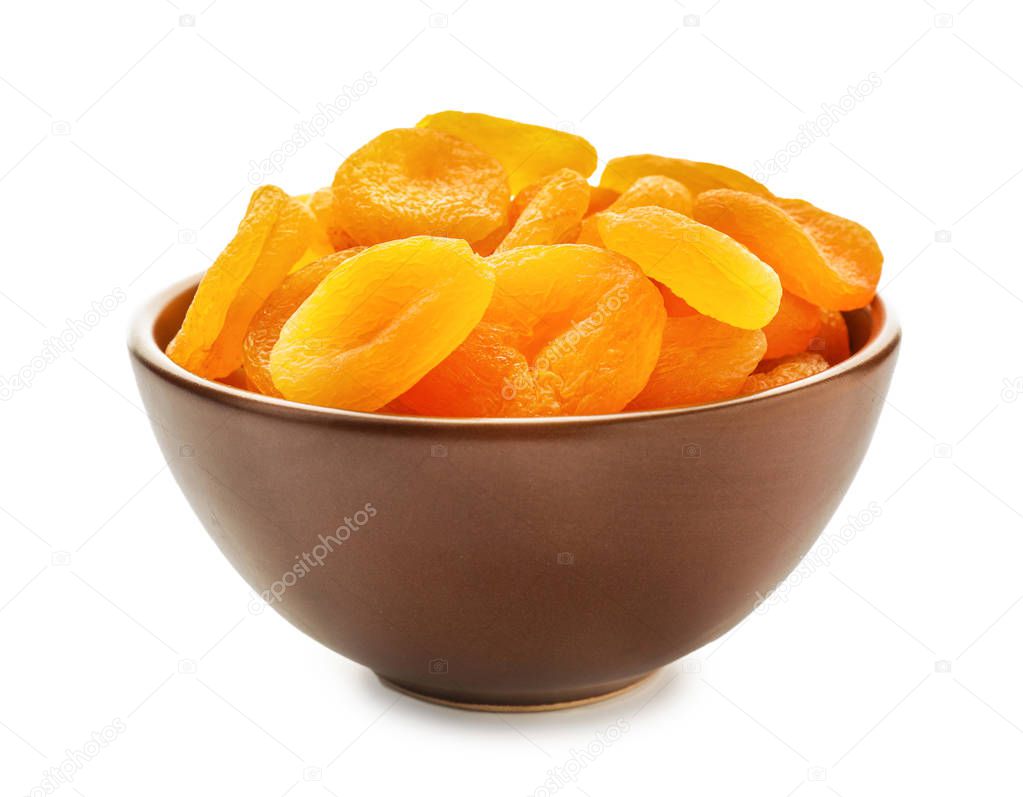 Bowl with dried apricots on white background