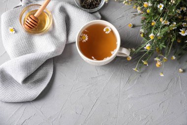 Fincan lezzetli papatya çayı ve masa lambası tatlım