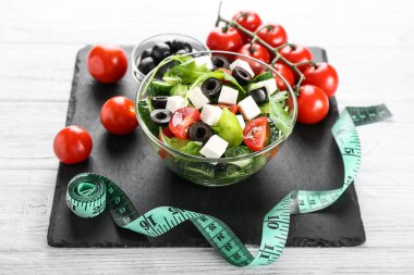 Sağlıklı taze salata ile kase ve teyp kayrak plaka üzerinde ölçüm. Diyet kavramı