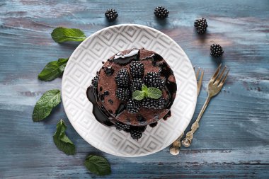 Lezzetli çikolatalı krep ve ahşap masa üzerinde meyveleri ile plaka