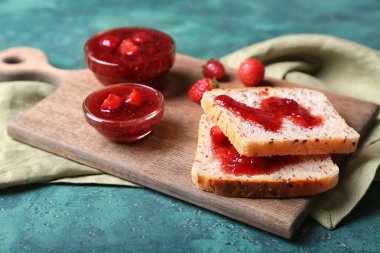 Kurulu ile dilim ekmek ve yeşil masada lezzetli çilek reçeli