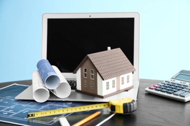 Çizimleri ve tablo üstünde laptop ile ev modeli. İpotek kavramı