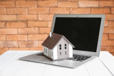 Masa üstünde laptop ile ev modeli. İpotek kavramı