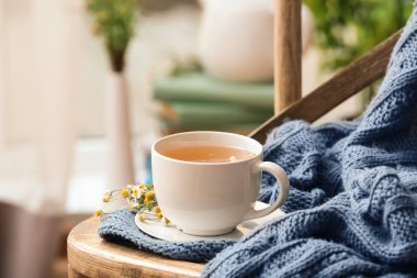 Ekose sandalye ile lezzetli papatya çayı fincan