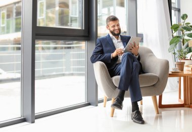 Koltukta oturan tablet bilgisayar ile işadamı