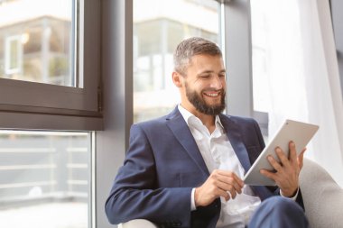 Koltukta oturan tablet bilgisayar ile işadamı