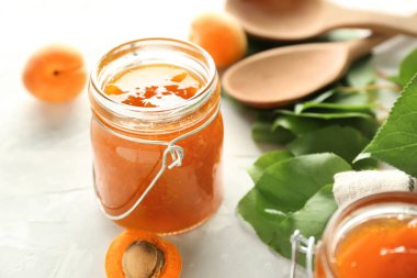 Işık tablosu üzerinde tatlı kayısı reçelli kavanoz