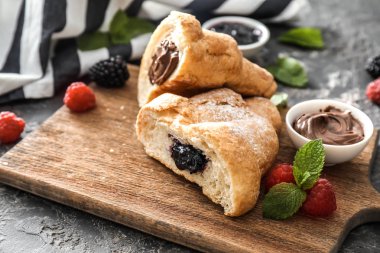 Çikolatalı hamur ve ahşap tahta üzerinde reçel ile lezzetli ay çöreği