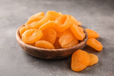 Gri arka plan üzerinde kuru kayısı ile kase