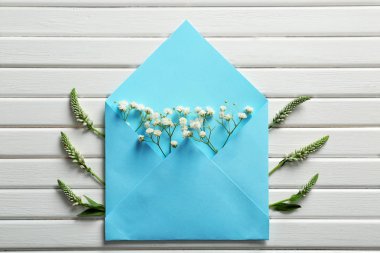 Çiçekler Beyaz ahşap zemin üzerine açık posta zarfı