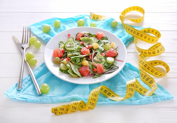 健康的なフレッシュ サラダ プレートし 木製のテーブル上のテープを測定します ダイエットの概念 — ストック写真