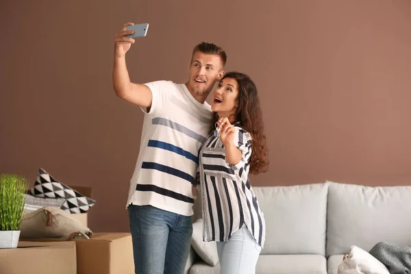 Szczęśliwa Młoda Para Biorąc Selfie Kluczem Ich Nowego Domu Pomieszczeniu — Zdjęcie stockowe