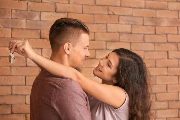 Feliz Pareja Joven Con Llave Nueva Casa Cerca Pared Ladrillo —  Fotos de Stock