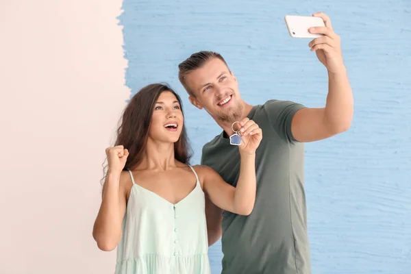Szczęśliwa Młoda Para Biorąc Selfie Kluczem Ich Nowy Dom Kolor — Zdjęcie stockowe