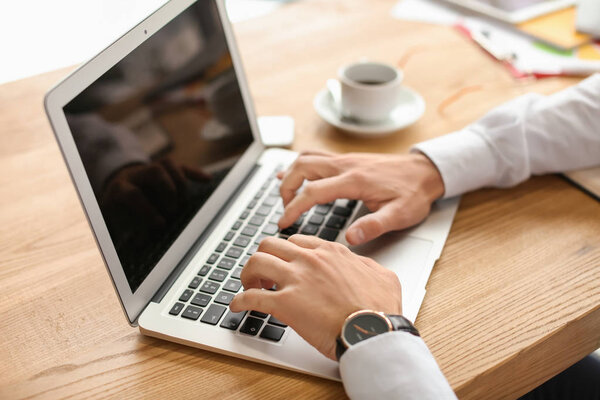 Businessman working with laptop in office, closeup