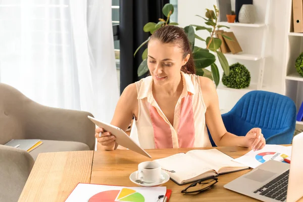 Young businesswoman with tablet PC working in office