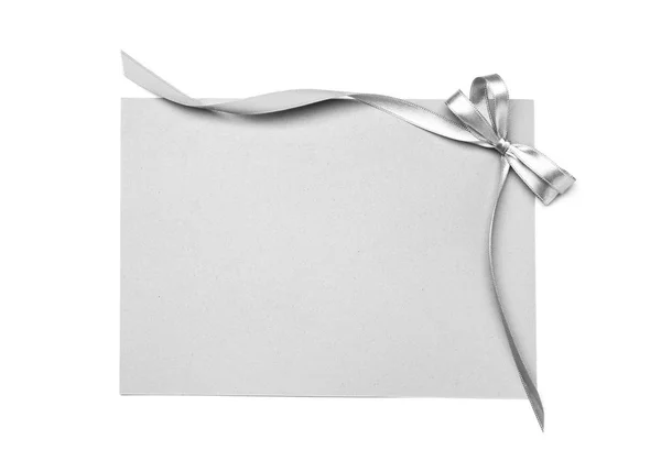 Prázdný Papír Karta Stříbrnou Stuhou Luk Bílém Pozadí — Stock fotografie