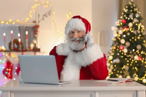 Santa Claus Pracy Laptopie Podczas Rozmowy Przez Telefon Pokoju Urządzone — Zdjęcie stockowe