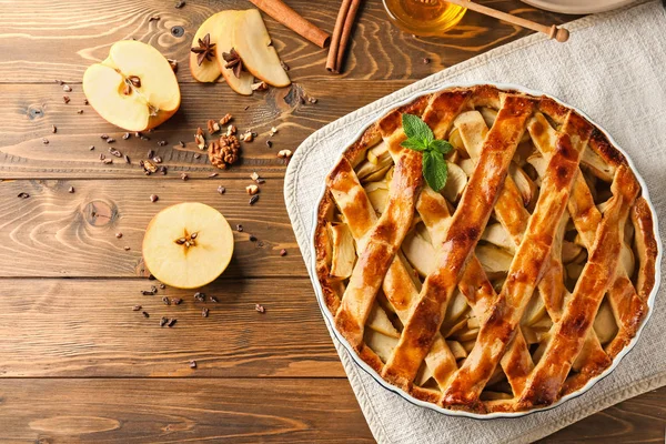 Stock image Dish with delicious apple pie on wooden table