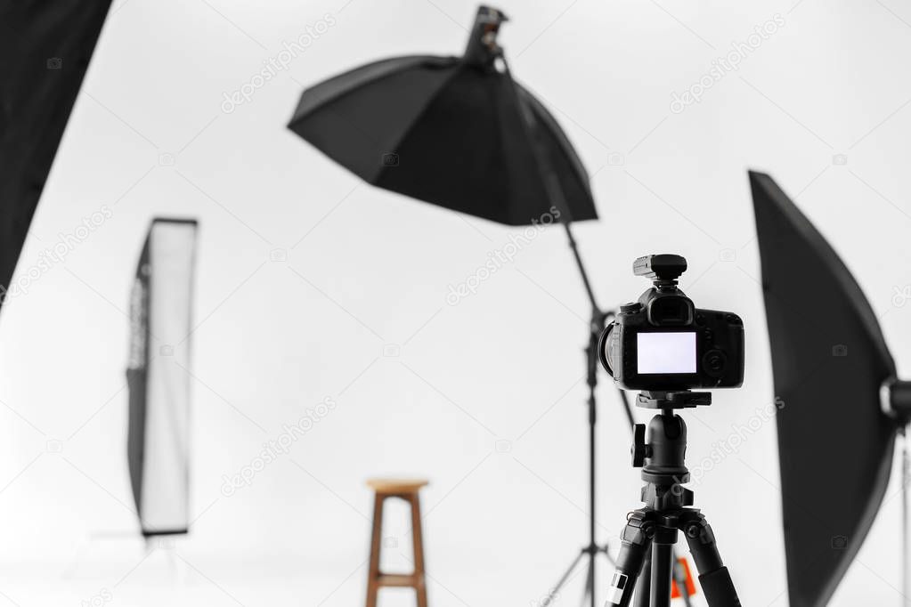 Professional camera on tripod in photo studio