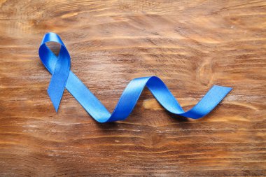 Ahşap zemin üzerine mavi kurdele. Kanser kavramı