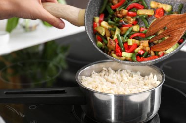 Kadın sebze mutfakta haşlanmış pirinç ile tencere içine ekleme