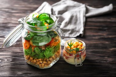 Ahşap masa üzerinde mason kavanoz lezzetli sebze salatalar