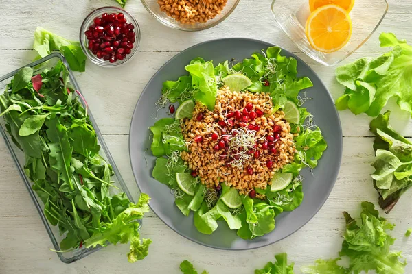 健康的なサラダと白い木製テーブルに食材のプレート — ストック写真