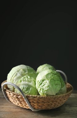 Ahşap masa üzerinde taze lahana ile hasır sepet