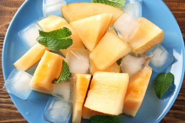 Buz küpleri ile Olgun kavun tabağa dilimlenmiş