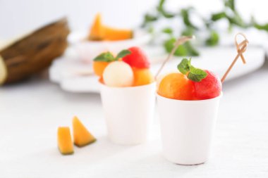 Bardak taze kavun ve karpuz topları üzerinde masa lambası ile