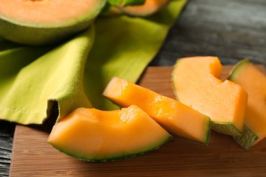 Ahşap masa, closeup kesme olgunlaşmış kavun parçaları