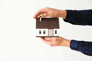 Ev modeli üzerinde açık renkli tutan adam