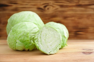 Ahşap masa üzerinde tüm ve dilimlenmiş lahana