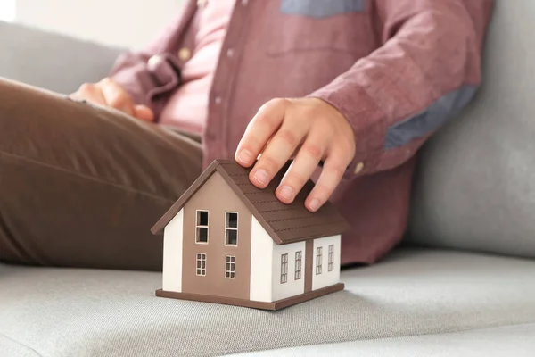 Mann Mit Hausmodell Auf Sofa Sitzend Nahaufnahme Hypothekenkonzept — Stockfoto