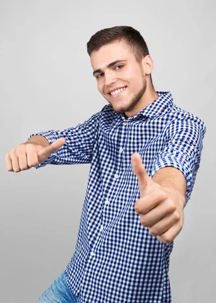 Przystojny Młody Człowiek Pokazuje Gest Kciuk Ups Jasnym Tle — Zdjęcie stockowe