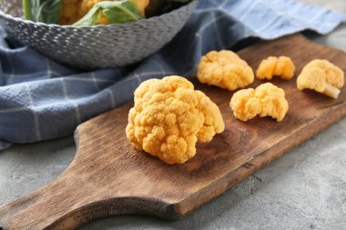 Ahşap tahta ile gri masada sarı karnabahar