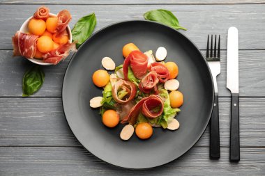 Lezzetli kavun topları plaka üzerinde jambon ve mozzarella peyniri ile