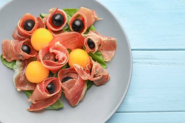 Lezzetli kavun topları jambon ve plaka üzerinde zeytin ile