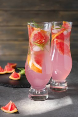 Taze greyfurt gri masada bardaklarda rosemary ile kokteyl