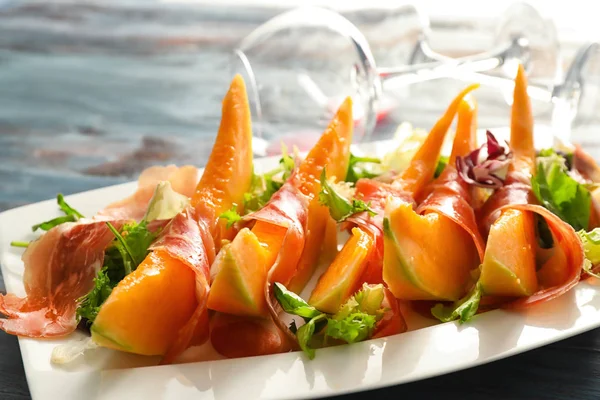 Delicious melon with prosciutto on plate