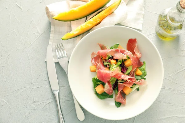Delicious salad with melon and prosciutto on plate