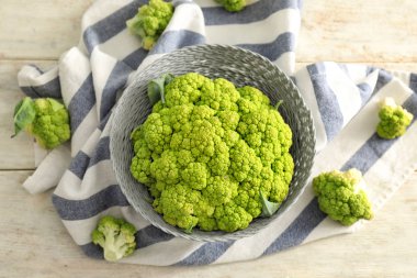 Ahşap masa üzerinde yeşil karnabahar lahana ile kase