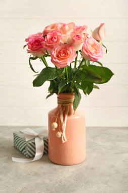 Güzel güller ve hediye kutusu gri tablo vazo