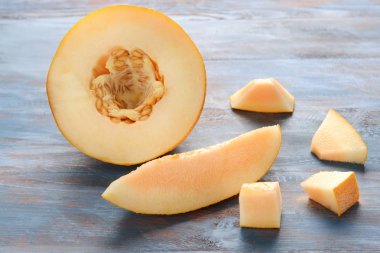 Ahşap masa üzerinde olgunlaşmış kavun dilimli