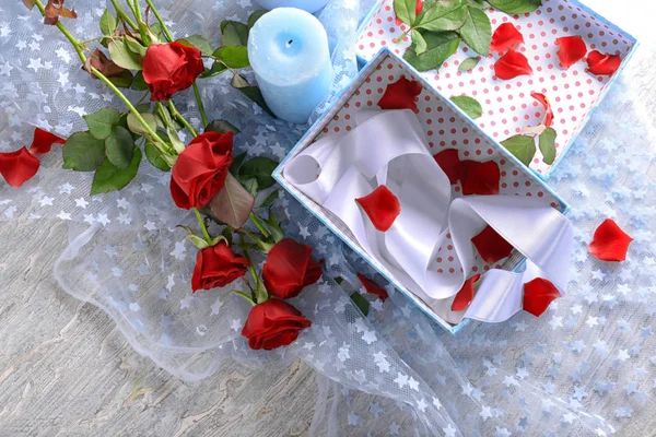 美丽的花束红色玫瑰和礼物盒在桌上 — 图库照片